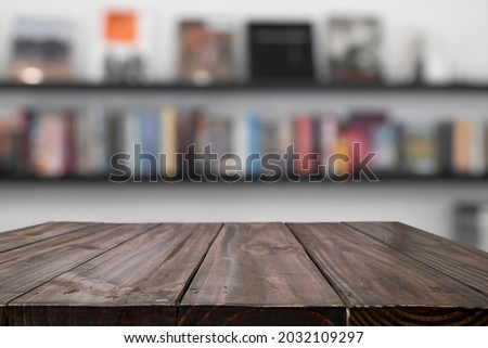 Empty wood table with blurred background of bookstore or library. For montage display products.