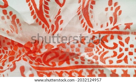Silk fabric, ruby red shades of delicate exquisite colors on a white background, photo of a Paisley print. Texture, pattern, collection