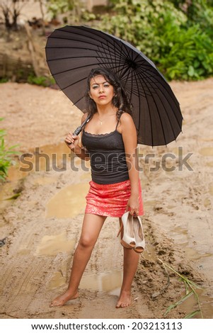 Young attractive Ecuadorian lady walking through mud with bare feet