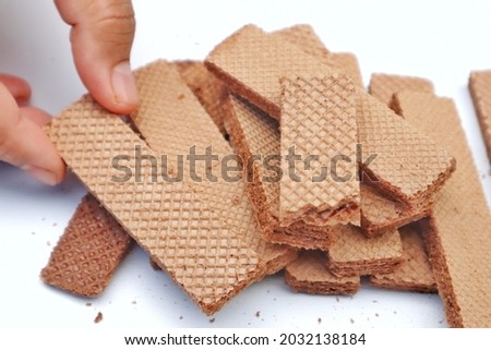 Wafers with chocolate cream isolated on white background. Hand hold wafers.