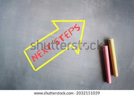 Business concept. Chalkboard drawing image of arrow with text NEXT STEPS