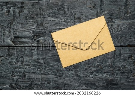 A paper postal envelope on a wooden table. The concept of mail correspondence. Flat lay.