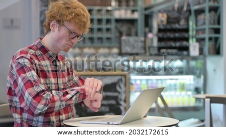 Redhead Young Man with Laptop in Cafe having Wrist Pain