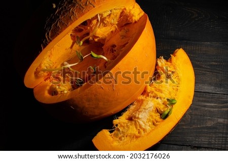 Cut out a slice of pumpkin, contrast photo on a dark background, top view.
