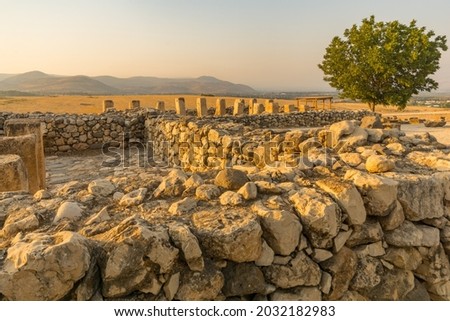 Sunset view of ancient Israelite buildings remains, with trees and landscape, in Tel Hazor National Park, a UNESCO World Heritage Site in Northern Israel Royalty-Free Stock Photo #2032182983