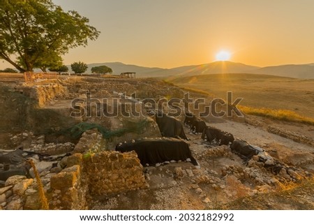 Sunset view of ancient Israelite buildings remains, with trees and landscape, in Tel Hazor National Park, a UNESCO World Heritage Site in Northern Israel Royalty-Free Stock Photo #2032182992