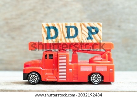 Fire ladder truck hold letter block in word DDP (Abbreviation of Delivered duty paid) on wood background