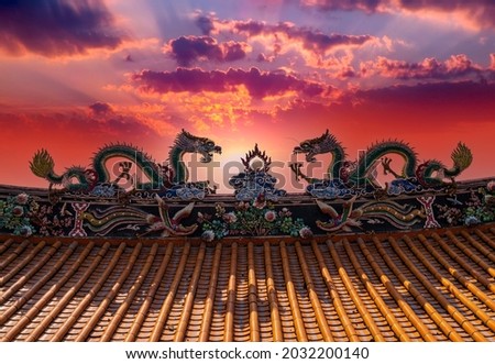 Chinese dragon sculpture on house roof in sunset. This is traditional architecture art in South China.