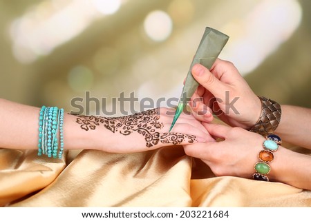 Process of applying Mehndi on female hand, close up Royalty-Free Stock Photo #203221684