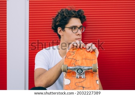 man posing with his skateboard