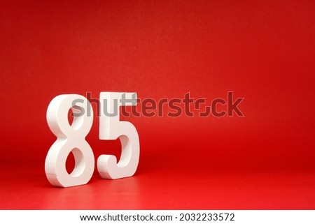 Eighty Five ( 85 ) white number wooden Isolated Red Background with Copy Space - New promotion 85% Percentage   Business finance or birthday Concept - advertise banner picture online with copy space Royalty-Free Stock Photo #2032233572