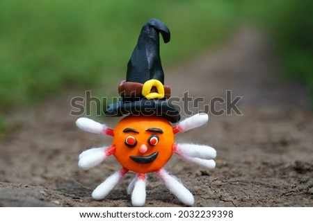 A figure of a virus made of plasticine in a hat. Halloween theme. Festive decorations.