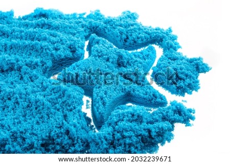 Blue sand on a white background and the outline of a star from the sand