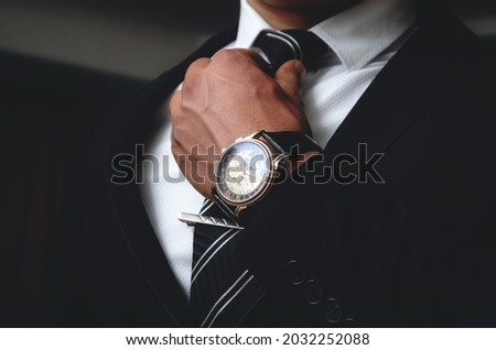 Men's watches. An accessory for men. A man in a suit on a black background. Royalty-Free Stock Photo #2032252088