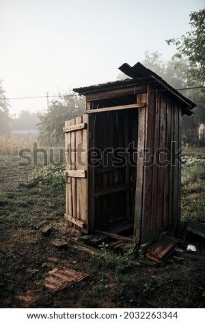 Old rural toilet early at dawn in fog, village Royalty-Free Stock Photo #2032263344