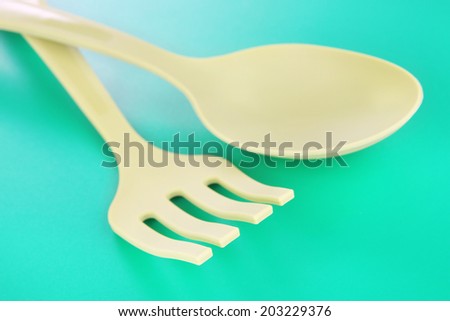 Plastic kitchen utensils on green background