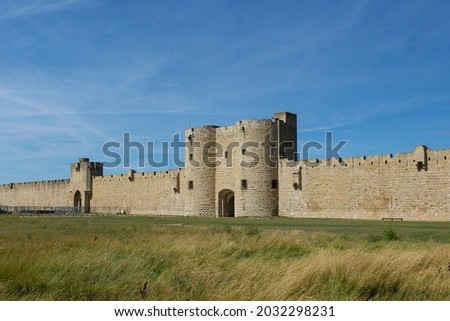 Fortified wall and gate to the old medieval town of Aigues Mortes, Gard, Occitania, Camargues, France. Western European military architecture. Royalty-Free Stock Photo #2032298231