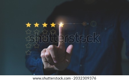 Customer hand touching to yellow illustration 5 stars virtual screening monitor for satisfaction evaluation survey and review. Royalty-Free Stock Photo #2032309376