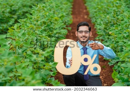 Young indian agronomist or financier showing zero percent sign or symbol at agriculture field
