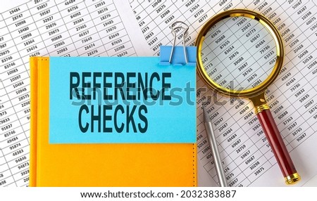 REFERENCE CHECKS text on sticker on notebook with magnifier and chart. Business