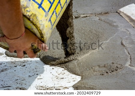 Worker Spreading Building Screed on a Floor of a House during Energy Redevelopment Work on Blurred Background Royalty-Free Stock Photo #2032409729