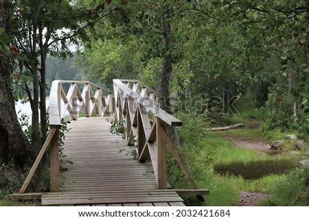 Beutiful white, wooden bridge in the nature helping the hikers to make  it to their destination. The photo is taken in Liesjärvi National Park in Finland. Selective focus.