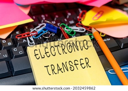 Conceptual display Electronic Transfer. Word for transaction that takes place over a computerized network Multiple Assorted Collection Office Stationery Photo Placed Over Table