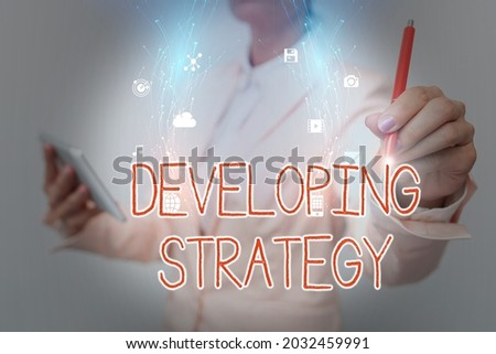 Conceptual caption Developing Strategy. Conceptual photo Game plan that sets specific goals and objectives Business Woman Using Phone While Presenting New Futuristic Virtual Display.