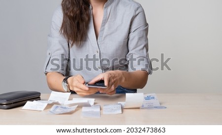 Personal Finance, the woman considers the costs, receipts and invoices, enter your expenses in the app for keeping track of the money. Family budget. Royalty-Free Stock Photo #2032473863