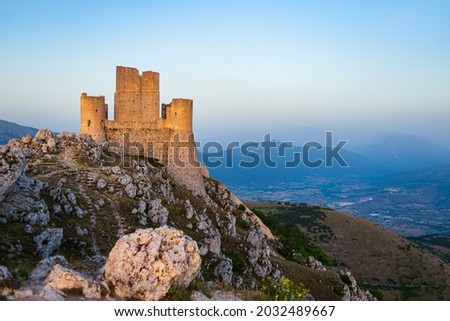 Castle ruins on mountain top at Rocca Calascio, italian travel destination, landmark in the Gran Sasso National Park, Abruzzo, Italy. Clear blue sky at dusk Royalty-Free Stock Photo #2032489667
