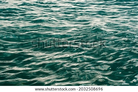 Sea surface with shallow waves. Abstract artistic background on the marine theme. Selective focusing in the center.