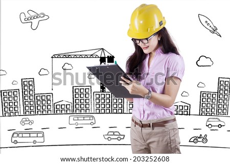 Construction safety inspector marking her checklist in front of project design