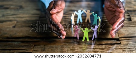 Inclusion, Diversity And Equality. African Hands Safeguard Paper Shapes Royalty-Free Stock Photo #2032604771