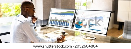 African American Business Desktop Looking At Graphs On Computer