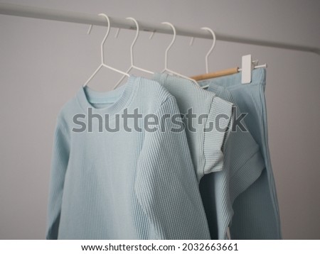 handicraft, clothing manufacturing, baby clothes hanging on the rail. pastel colors      