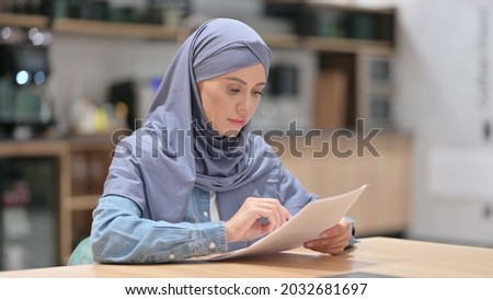 Arab Woman Reading Documents at Work