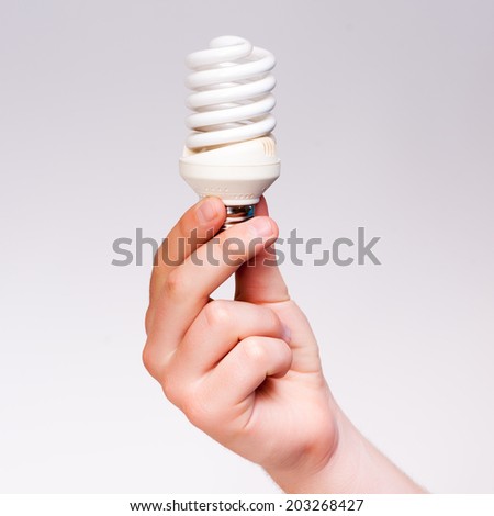 hand holding energy saving lamp on a white background