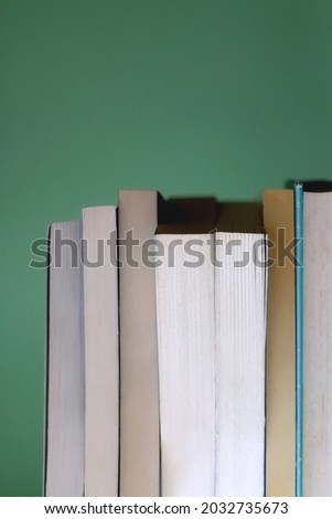Stack of books with blue and green covers. Selective focus.