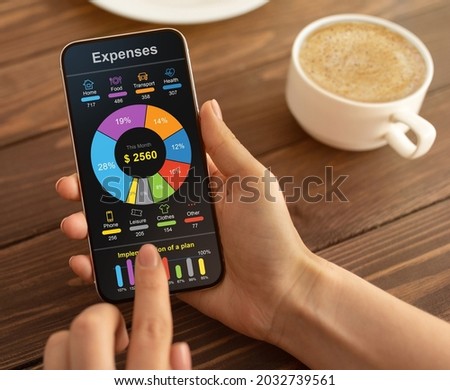 Mobile Phone App For Money, Budget And Expense Tracking concept. Unrecognizable woman checking her monthly expenses on smartphone while drinking coffee at cafe, cropped, collage Royalty-Free Stock Photo #2032739561