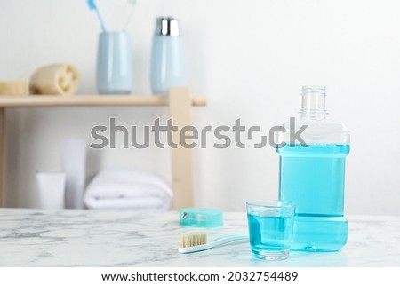 Mouthwash and other oral hygiene products on white marble table in bathroom, space for text Royalty-Free Stock Photo #2032754489