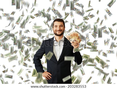 successful smiley businessman standing under money rain and holding euro