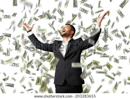 happy excited businessman raising hands up and looking up under money rain