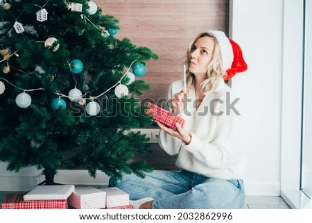 Young girl wrapping and signing Christmas gifts  with pen at home.