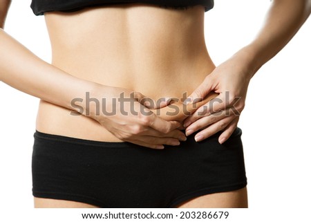 Young woman with hand on her tummy. Part of body. Close-up. Isolated over white background.