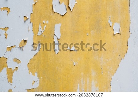 The texture surface of white and yellow color fade, peel off and crack wall damaged background Royalty-Free Stock Photo #2032878107