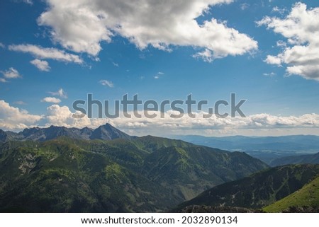 Aerial view of Slovakia tatra peaks in the background, with blue cloudy sky