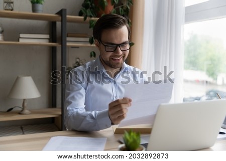 Happy excited business man reading received paper letter, loan document from bank, paid back mortgage notice, professional certificate. Student getting admission from school, college Royalty-Free Stock Photo #2032892873