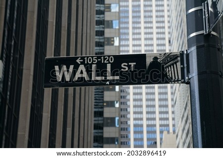 Wall Street sign in New York City on pole. High rise buildings in the background. NYC 