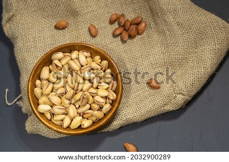 Nuts, Cashew, Pistachio, Almond, Pumpkin seeds, sunflower seeds are stylized in dramatic way with burlap background