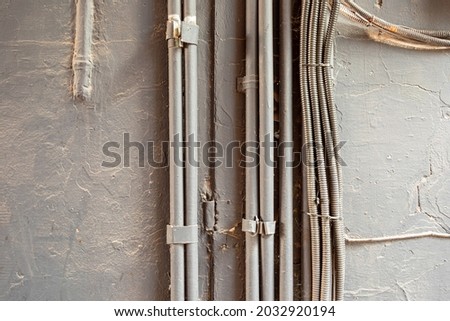 painted corrugated pipe for cable. On the wall Cable and wire in a metal sheath. Royalty-Free Stock Photo #2032920194